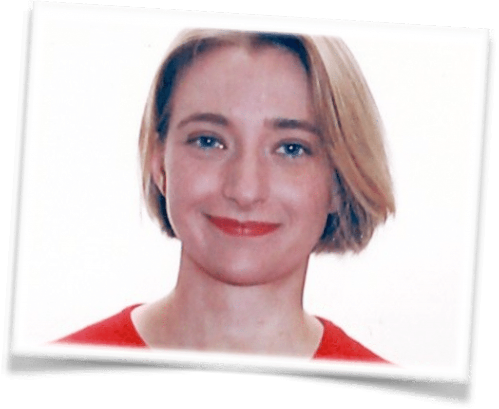 Lea Posma, a woman with short blonde hair and blue eyes, is smiling softly at the camera. She is wearing a red top against a plain white background, with the photo featuring a slightly tilted, framed border.