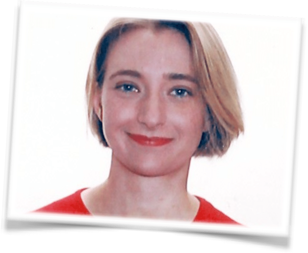 Lea Posma, a woman with short blonde hair and blue eyes, is smiling softly at the camera. She is wearing a red top against a plain white background, with the photo featuring a slightly tilted, framed border.