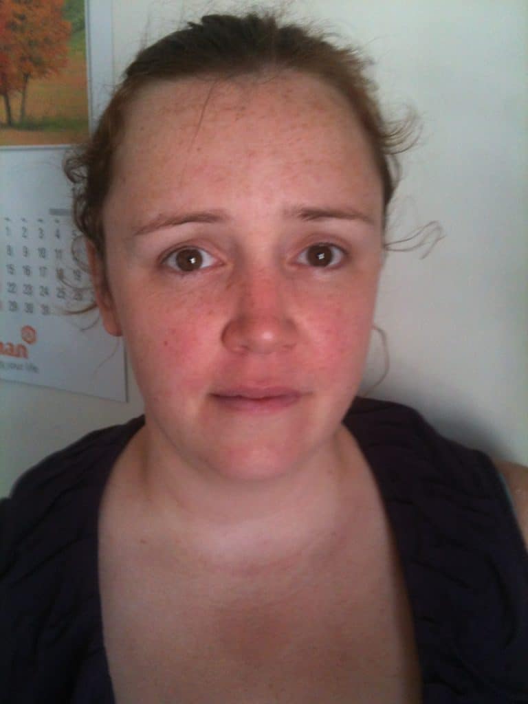 Nicola Haley, a woman with fair skin and reddish-brown hair, looks directly at the camera with a neutral expression. She stands indoors in front of a wall where a calendar is visible in the background.